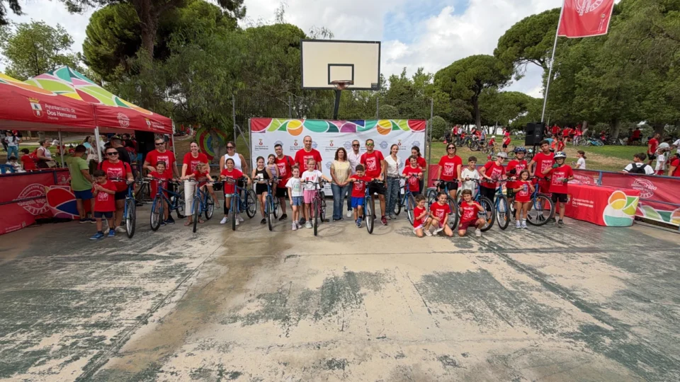 Participantes posan con bicicletas junto al escenario de la jornada en el Parque de los Pinos